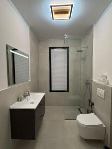 a bathroom with a toilet and a sink and a shower at Luis Luxury Apartment in Sarandë