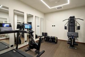 a gym with treadmills and exercise equipment in a room at WANDERLUST HOTEL & APARTMENTS - SUITE & SPA - Bardolino, Lago di Garda - Verona in Bardolino +159 photos