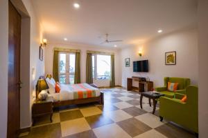 a bedroom with a bed and a couch and a tv at Alaya Stays Captains Nest 3 BHK Retreat With Garden & Scenic Views in Kasauli