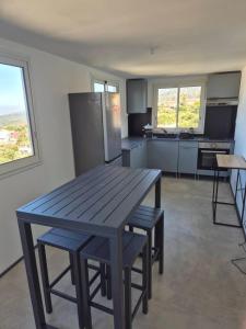 a kitchen with a wooden table and benches in it at Appartement 1 Chambre avec vue in Le Tampon