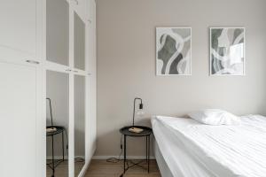 タンペレにあるHeartful 1BR Apartment with Balcony next to Railway Station - Hosted by 2ndhomesの白いベッドルーム(ベッド1台、スツール2台付)