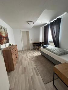 a bedroom with a bed and a dresser and a desk at Schönes 4-Zimmer Appartment, WLAN, Küche, BAD in Ilmenau