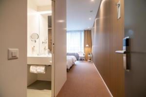 una camera d'albergo con un letto e un bagno di Trafo Hotel Baden a Baden