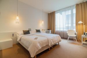 una camera da letto con un letto grande e una sedia di Trafo Hotel Baden a Baden