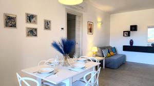 un salon avec une table et des chaises blanches dans l'établissement GIALE MARE Apartments, à Grottammare