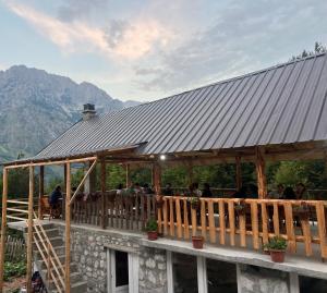 a restaurant with people sitting on a wooden deck at Rosi peak Guesthouse in Valbonë