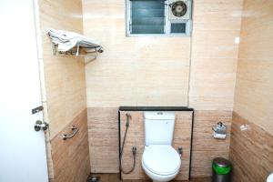 a small bathroom with a toilet and a window at Palani Andavar in Bangalore +17 photos