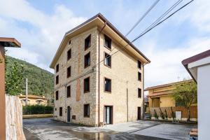 an old brick building with windows on a street at VOMAN Luxury Apartments in Pietrasanta