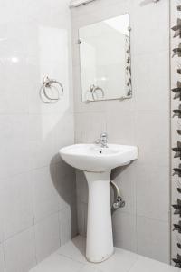 ShogiVatika Resorts Cottages的一间白色浴室，配有洗手池和镜子。