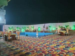 奥拉奇哈Hotel Rajwada palace的一个带游泳池和桌椅的舞台