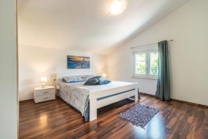 ein weißes Schlafzimmer mit einem Bett und einem Fenster in der Unterkunft Villa Roza by Kompas Villas in Vošteni + 52 Fotos