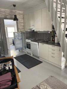 a kitchen with white cabinets and a stove top oven at Villa Winter Lake50 in Kuusamo