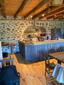 a kitchen with a counter and a table and chairs at La ferme du Liaumiers in Saint-Cirgues-de-Jordanne