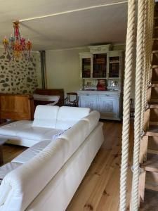a living room with two white couches and a table at La ferme du Liaumiers in Saint-Cirgues-de-Jordanne