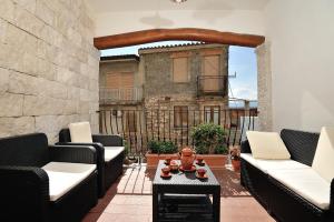a patio with couches and a table in front of a building at Villa Maddalena con parcheggio privato in Baunei +39 photos