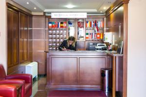 a woman standing behind a bar in a restaurant at Hotel M3 in Sarajevo