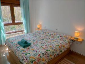 Una cama con una almohada azul encima en un dormitorio. en Encantador Apartamento cerca de Sierra Nevada y la Alhambra, en Pinos Genil