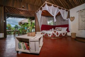 a bedroom with a bed and a book shelf at Hazotsara Guest House in Nosy Be