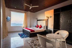 ShogiVatika Resorts Cottages的一间卧室，里面有一张床、一张桌子和几把椅子。