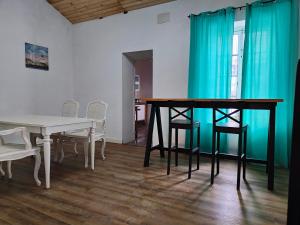 una sala da pranzo con tavolo, sedie e tende blu di Antigua Casa de Pescadores a San Pedro del Pinatar