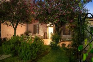 una casa con un cortile alberato e fiori rosa di Antigua Casa de Pescadores a San Pedro del Pinatar