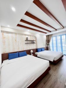- une chambre avec 2 lits dotés d'oreillers bleus dans l'établissement Chuỗi Villa Sun Feria 4 Ngủ OCE - Bể Bơi - Gần Biển - Trung tâm Bãi Cháy, à Hạ Long