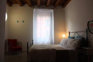 a bedroom with a bed with a window and a red chair at Residenza Navi in Verona