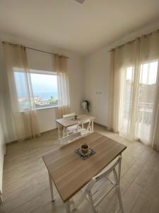 a living room with a table and a large window at La Casa di Sara in Porto Empedocle