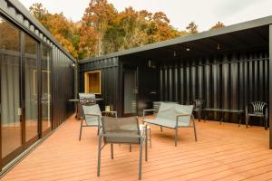 a deck with chairs and tables on a black building at No-12 Kasima Fan Zone in Kashima