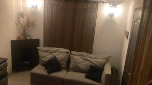 a couch in a living room with two pillows on it at Apartastudio con baño privado y chimenea in Chía +6 photos