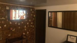 a bathroom with a television on a brick wall at Apartastudio con baño privado y chimenea in Chía