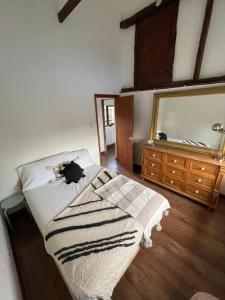 a bedroom with a bed and a mirror on the wall at Milk Barn - Rustic farm stay in Great Chart