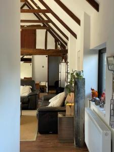 a living room with a couch and a table at Milk Barn - Rustic farm stay in Great Chart