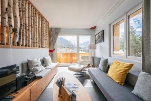 a living room with a couch and a tv at Près du Mélèze-Val Cenis-Sardières in Val Cenis