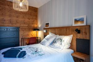 a bedroom with a bed with a wooden wall at Près du Mélèze-Val Cenis-Sardières in Val Cenis