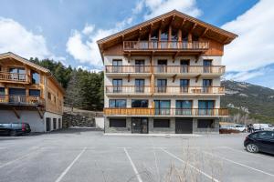 a building with a parking lot in front of it at Près du Mélèze-Val Cenis-Sardières in Val Cenis
