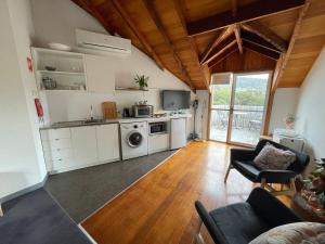 a kitchen with white cabinets and a stove top oven at Gaol House Cottages in Bicheno