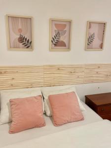 a bedroom with a white bed with two pink pillows at Central Lisbon Apartment Santos Walk to Cais do Sodré in Lisbon