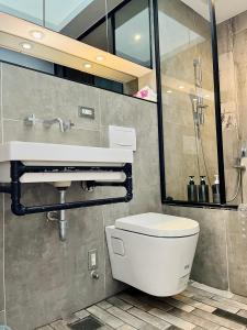a bathroom with a white toilet and a sink at 阡陌-頂加民宿 in Tainan +12 photos