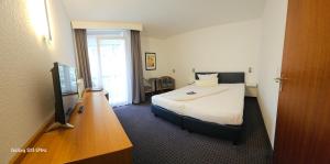 a hotel room with a bed and a television at Aparthotel Höper in Oyten
