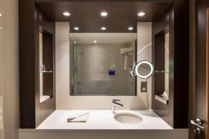 a bathroom with a sink and a mirror at Radisson Blu Hotel, Edinburgh City Centre in Edinburgh +105 photos