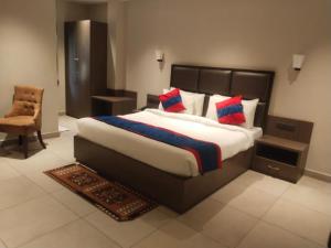 a bedroom with a large bed and a chair at VIORAY INN in Deoghar