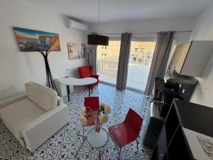 a living room with a white couch and red chairs at MH Sliema by Malta Holidays in Sliema