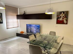 a dining room with a glass table and chairs at Apartment Quintana Center Parking Gratis in Lucena