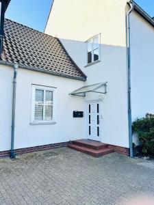 a white house with a white door and windows at Galerie-Dachstudio- Ruhig & kompakt-Waschmaschine- WLAN- Parkplatz in Wolfsburg