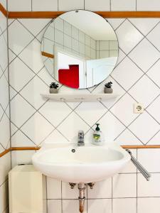 a bathroom with a sink and a mirror at Galerie-Dachstudio- Ruhig & kompakt-Waschmaschine- WLAN- Parkplatz in Wolfsburg