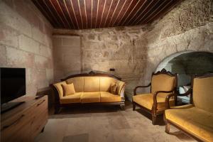 un salon avec un canapé et une télévision dans l'établissement Azalea Terrace Cave Hotel, à Gorëme