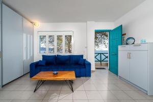 a living room with a blue couch and a table at The Greek Getaway in Lóngos
