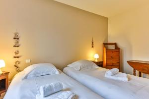two twin beds in a room with a table and a desk at Les Pinsons - Jardin - Parking - Wifi in Challans