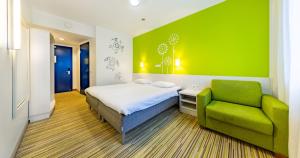 a bedroom with a bed and a green wall at Tallink Express Hotel in Tallinn